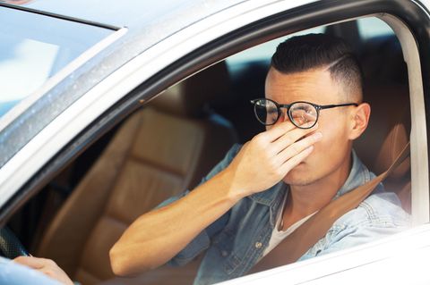 Ein wegen hoher Benzinpreise frustrierter Autofahrer reibt sich die Augen