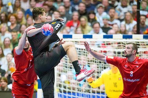 Samuel Röthlisberger aus der Schweiz (l.) versucht Deutschlands Julian Köster bei der Handball-WM am Wurf zu hindern