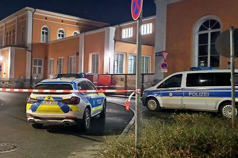 Einsatzfahrzeuge der Polizei stehen vor dem abgesperrten Hauptbahnhof in Passau