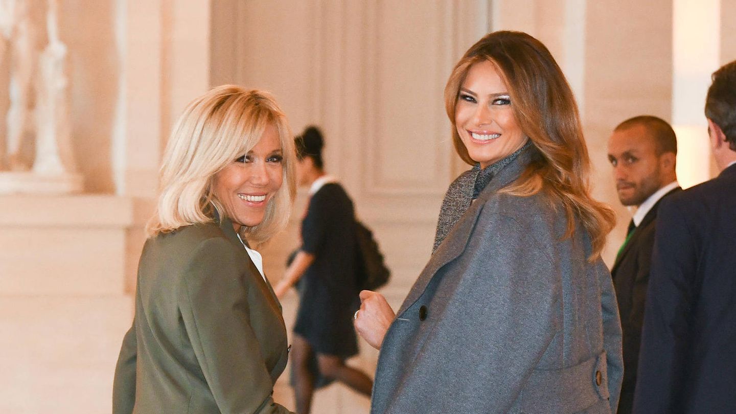 Brigitte Macron und Melania Trump blicken für die Kameras über ihre Schultern