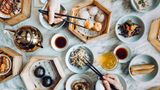 In den quirligen Dim-Sum-Restaurants Hongkongs werden "Herzensfreuden" serviert – so die wörtliche Übersetzung. Die dampfenden Körbe mit gefüllten Teigtaschen kommen nicht alle auf einmal. Hier gilt die Kunst des dosierten Bestellens. Zum "Yum Cha", dem traditionellen Dim-Sum-Essen, gehört immer Tee − er hilft bei der Verdauung. Familien verbringen hier den ganzen Vormittag, probieren nach und nach verschiedene Häppchen. Das Gespräch ist dabei genauso wichtig wie das Essen selbst