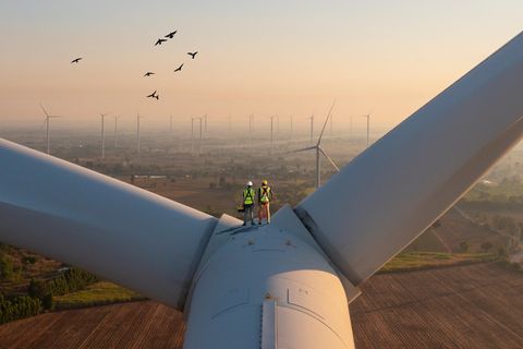 Zwei Arbeiter auf dem Generatorenraum eines Windrades