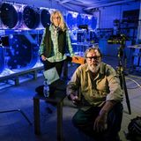 Quallen als Fotoprojekt: Das Fotografenpaar Heidi und Hans-Jürgen Koch mit Kamera und Stativ vor runden Quallenaquarien