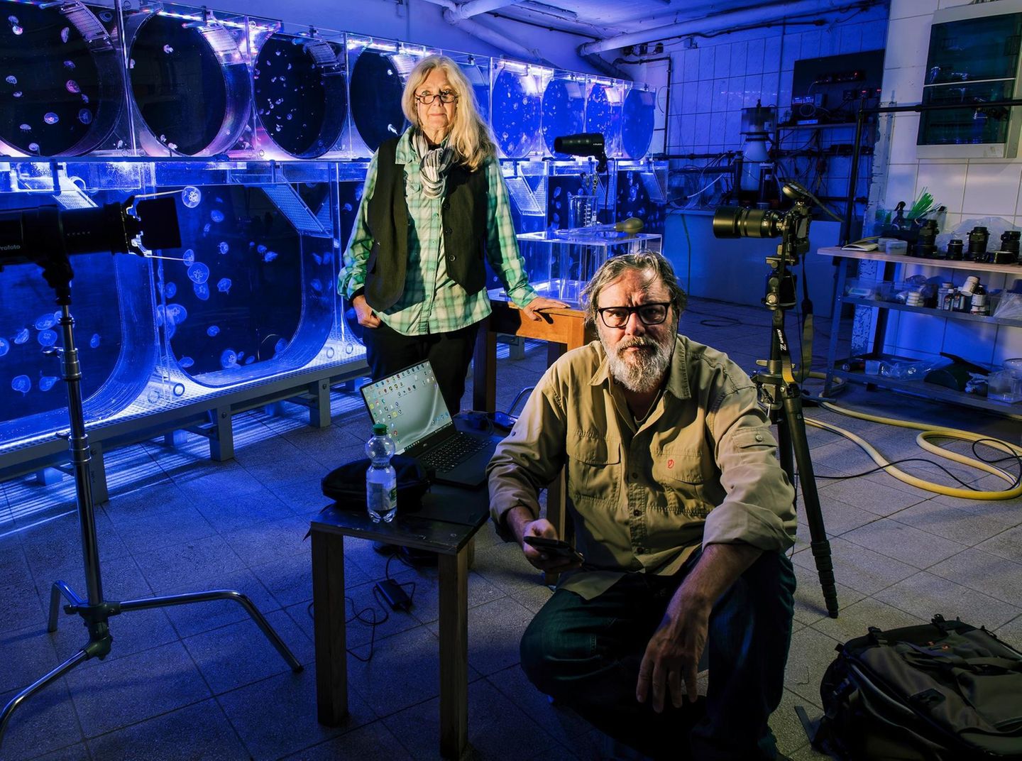Quallen als Fotoprojekt: Das Fotografenpaar Heidi und Hans-Jürgen Koch mit Kamera und Stativ vor runden Quallenaquarien Quallen als Fotoprojekt: Das Fotografenpaar Heidi und Hans-Jürgen Koch mit Kamera und Stativ vor runden Quallenaquarien