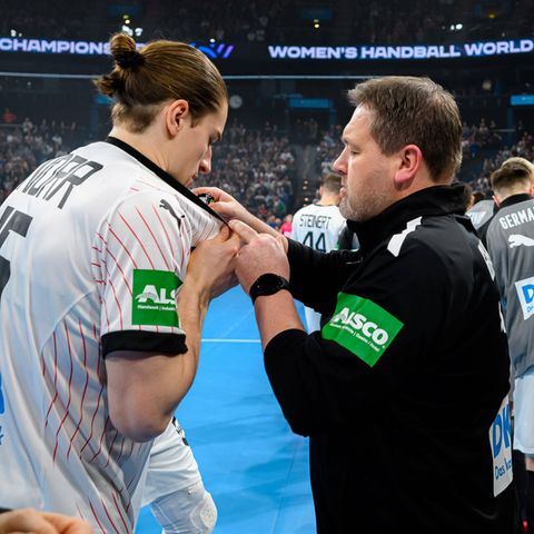 Physiotherapist Martin Leuthner gives some drops of mint oil on the jersey of handball star Juri Knorr