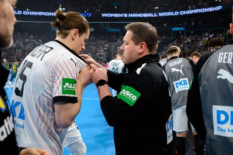 Physiotherapeut Martin Leuthner gibt einige Tropfen Minzöl auf das Trikot von Handballstar Juri Knorr