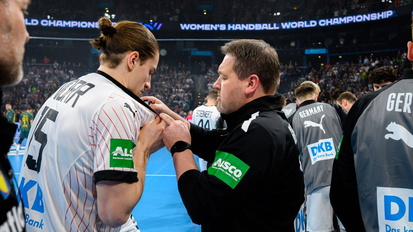 Physiotherapeut Martin Leuthner gibt einige Tropfen Minzöl auf das Trikot von Handballstar Juri Knorr