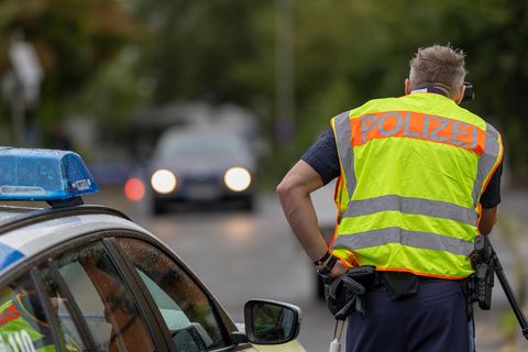 Eine Frau reicht einem Polizisten ihrern Führerschein aus dem Autofenster