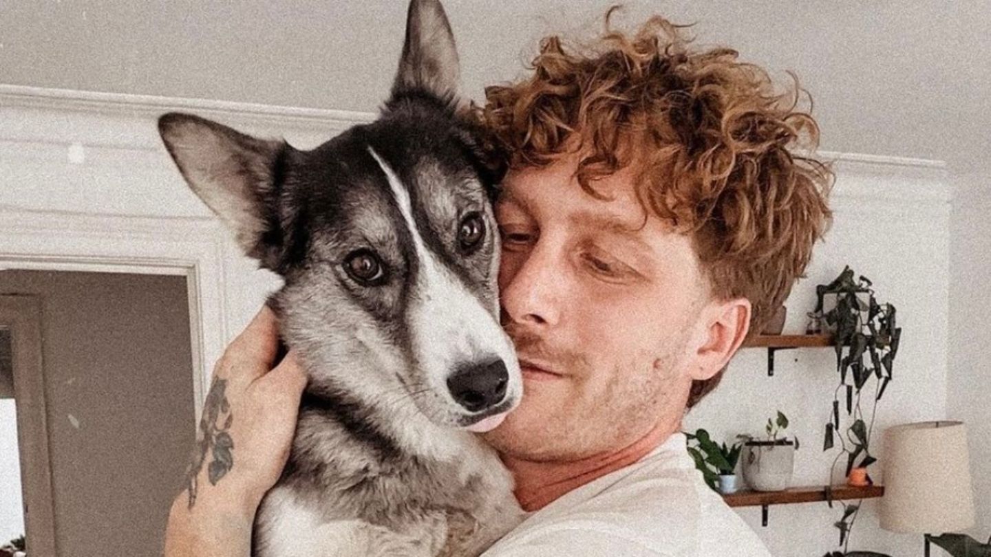 Malte Zierden hält einen Hund auf dem Arm.