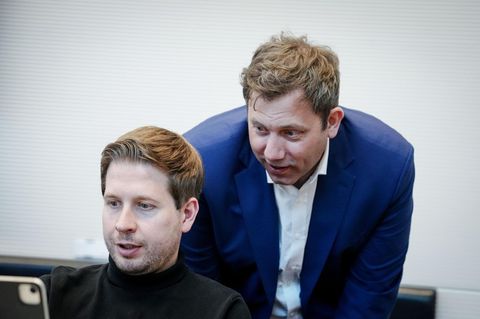Lars Klingbeil beugt sich über den an einem Laptop arbeitenden Kevin Kühnert
