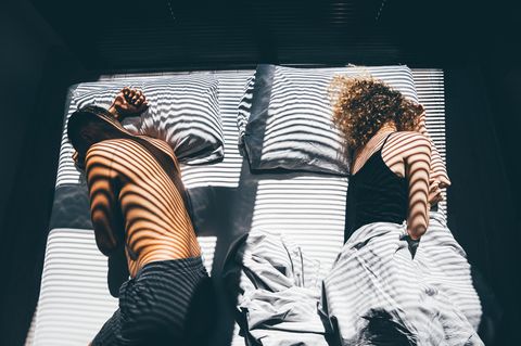 Statt Sex: Ein Mann und eine Frau liegen voneinander abgewandt auf einem Doppelbett