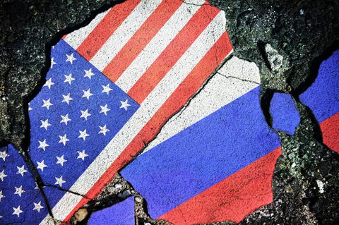 Eine US-amerikanische und russische Flagge sind auf Stein gemalt und in Stücken aneinander gelegt