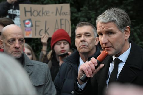 Björn Höcke steht am Freitagnachmittag in Aschaffenburg und spricht vor einem Schild mit der Aufschrift Höcke=Nazi