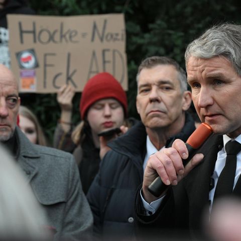 Björn Höcke steht am Freitagnachmittag in Aschaffenburg und spricht vor einem Schild mit der Aufschrift Höcke=Nazi