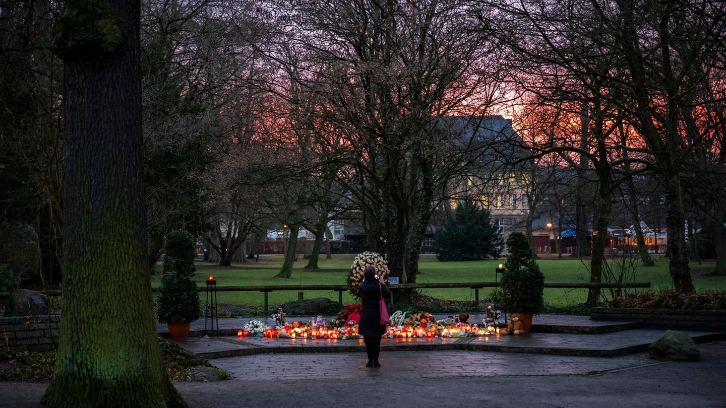 Eine Frau steht vor einer Gedenkstelle mit Grablichtern im Park Schöntal in Aschaffenburg Eine Frau steht vor einer Gedenkstelle mit Grablichtern im Park Schöntal in Aschaffenburg