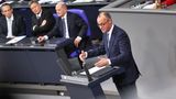 Friedrich Merz spricht im Bundestag, im Hintergrund sitzen Olaf Scholz und Robert Habeck