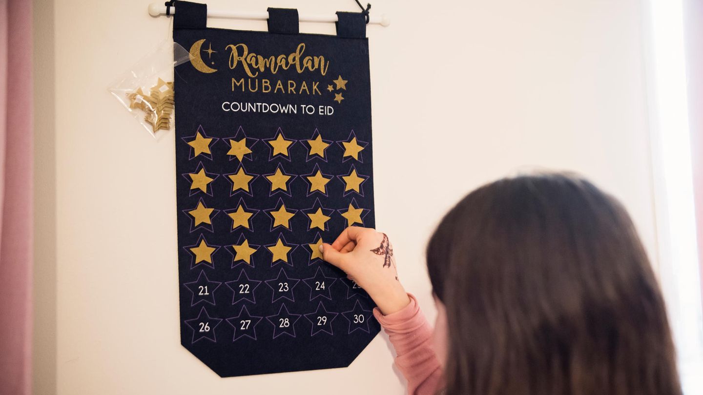 Mädchen steht vor einem Ramadan-Kalender