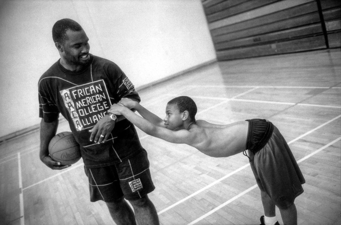 Während eines Basketball-Spiels hält sich der junge Derrell am Arm von Zach Harris fest Während eines Basketball-Spiels hält sich der junge Derrell am Arm von Zach Harris fest