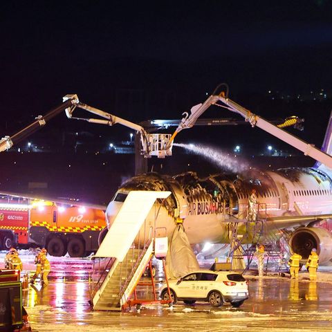 Zwei Ausleger mit Löschkanonen zielen auf ein Flugzeug in Südkorea