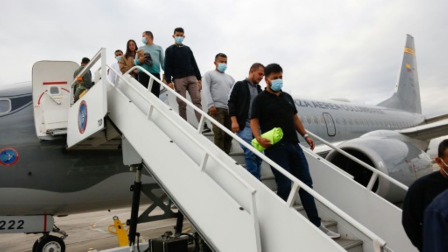 Abgeschobene Kolumbianer steigen aus einem Militärflugzeug