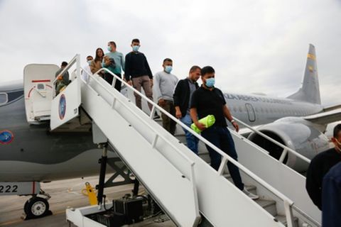 Abgeschobene Kolumbianer steigen aus einem Militärflugzeug