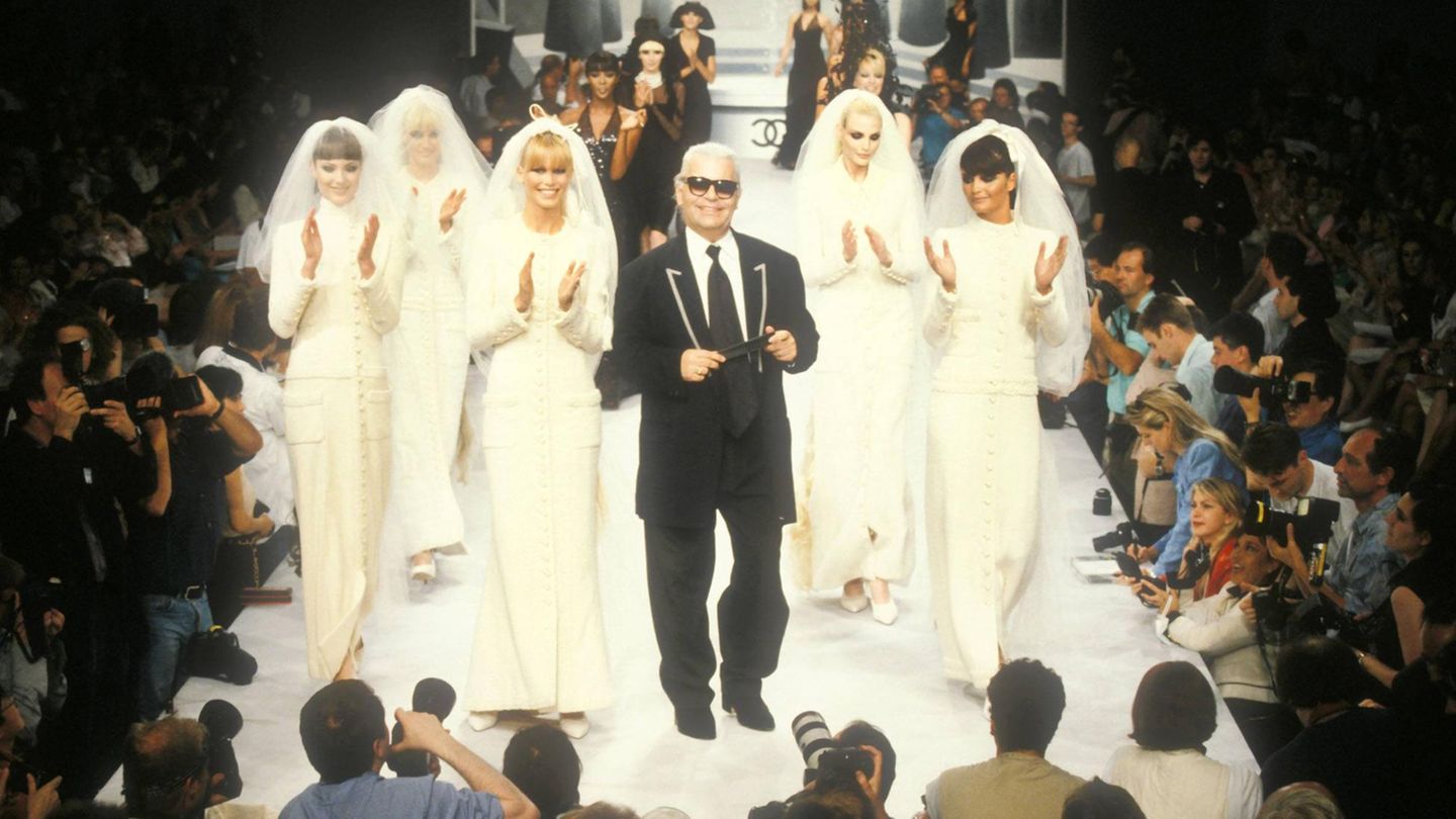 Karl Lagerfeld umringt von Models in weißen Couture-Kleidern