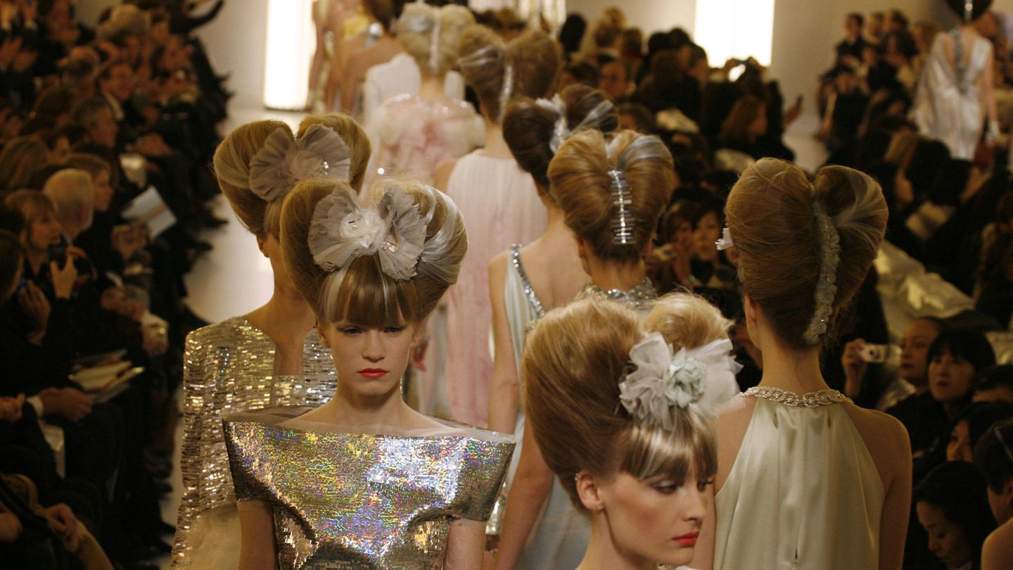 Chanel-Models mit silbernen Kleidern und hochtopierten Haaren laufen über den Laufsteg