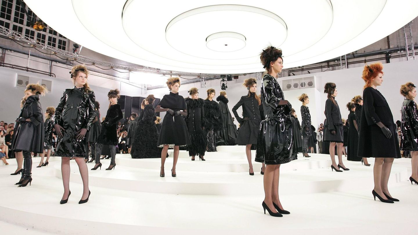 Chanel-Models in schwarzen Kleidern auf einem weißen, runden Laufsteg