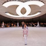 Showkulisse von Chanel mit großem Logoknopf, der über dem Laufsteg schwebt