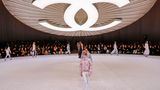 Showkulisse von Chanel mit großem Logoknopf, der über dem Laufsteg schwebt