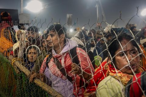 Pilger auf Indiens Pilgerfest Kumbh Mela an einem Zaun