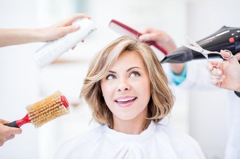Besser mit dem Dyson Airwrap: Frau ist umringt von Händen mit Schere, Bürste und Föhn.