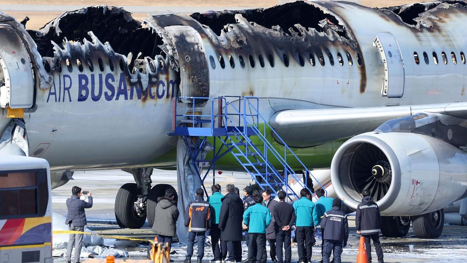 Ein Flugzug steht halb verbrannt auf einem Rollfeld des Flughafens in Busan, Südkorea