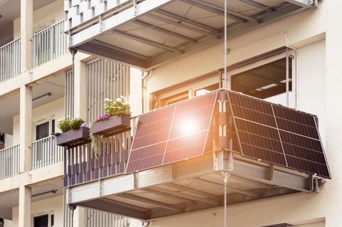 800-Watt-Grenze beim Balkonkraftwerk: Hausfassade mit Balkon, an dem vier Solarmodule angebracht sind.
