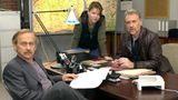 Robert Atzorn in brauner Lederjacke am Schreibtisch seines neuen Kommissariats im Tatort-Hamburg