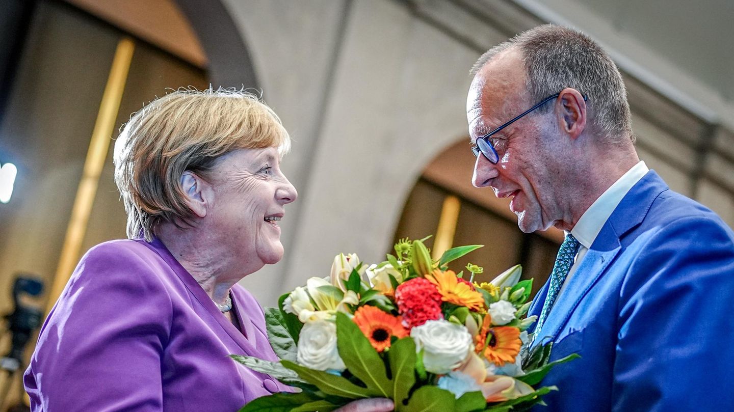 Angela Merkel und Friedrich Merz Friedrich Merz überreicht Angela Merkel einen Strauß bunter Blumen