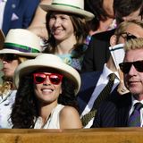 Boris und Lilly Becker sitzen auf einer Tribüne des Wimbledon-Turniers. Sie trägt einen Hut.