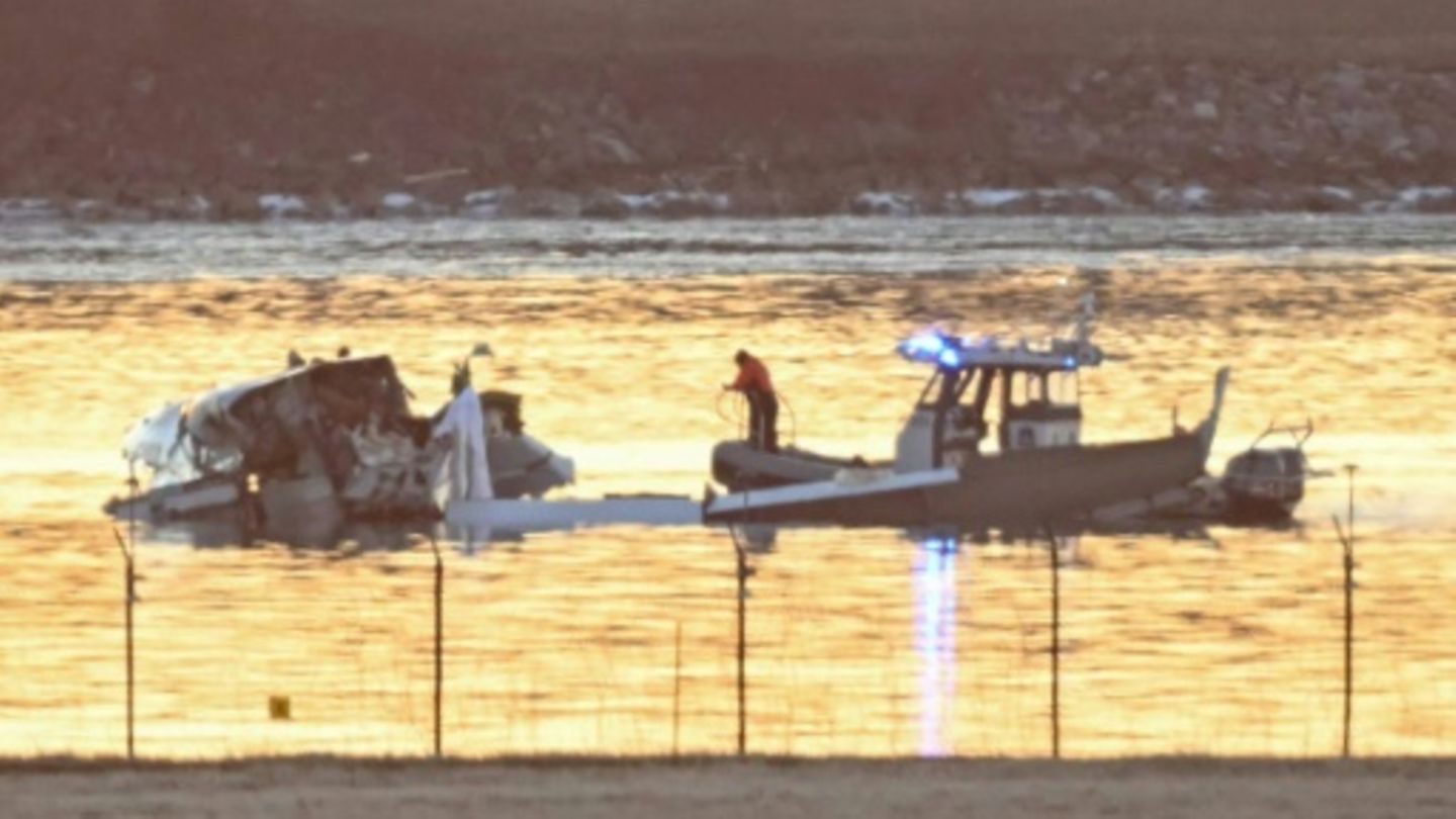 Ein Teil des Flugzeugwracks ragt aus dem Fluss (links)