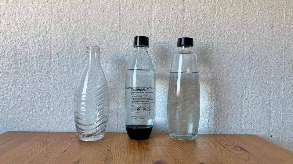 Die Flaschen des Sodastream E-Duo stehen neben der klassischen Glaskaraffe