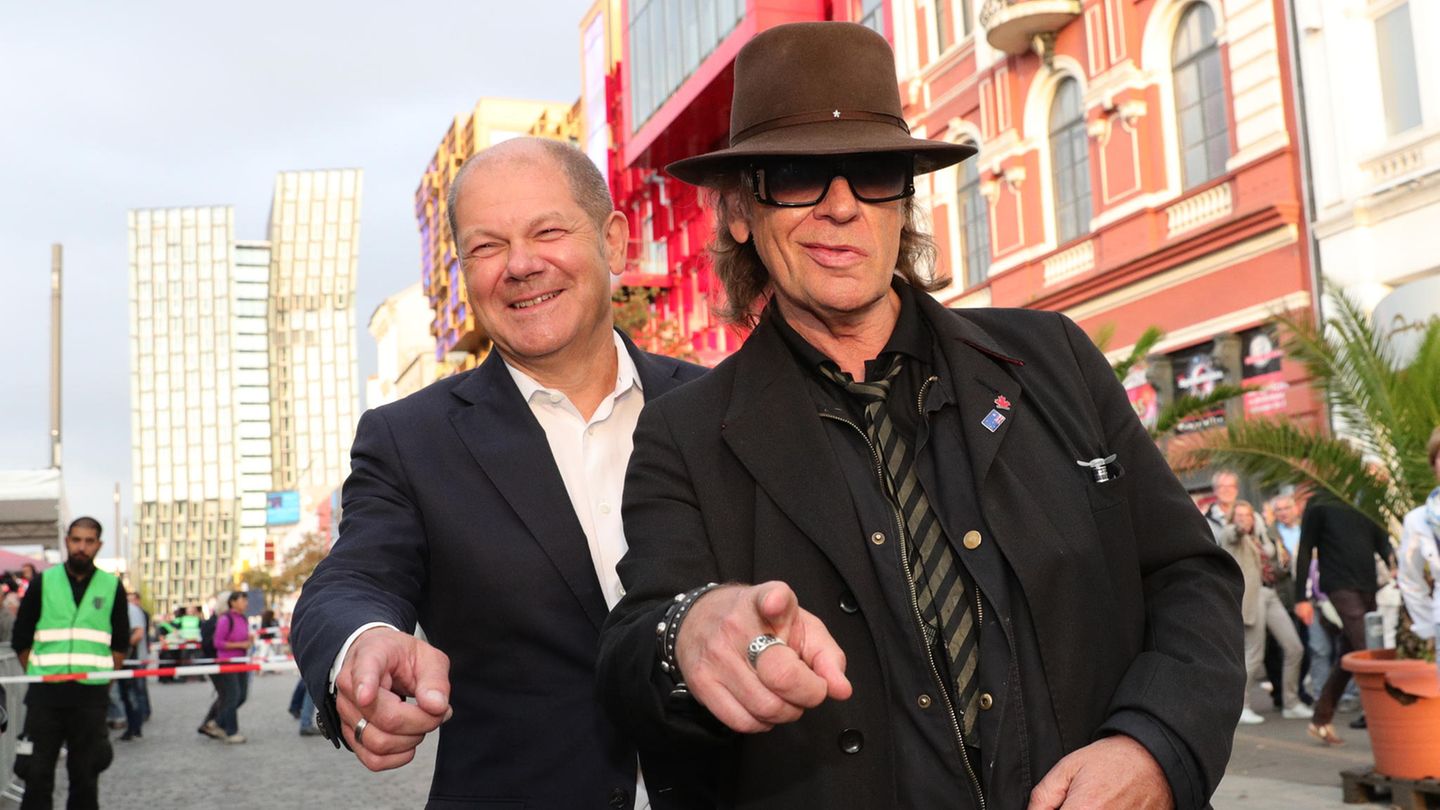 Olaf Scholz und Udo Lindenberg zeigen mit dem Finger in die Kamera