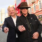 Olaf Scholz und Udo Lindenberg zeigen mit dem Finger in die Kamera