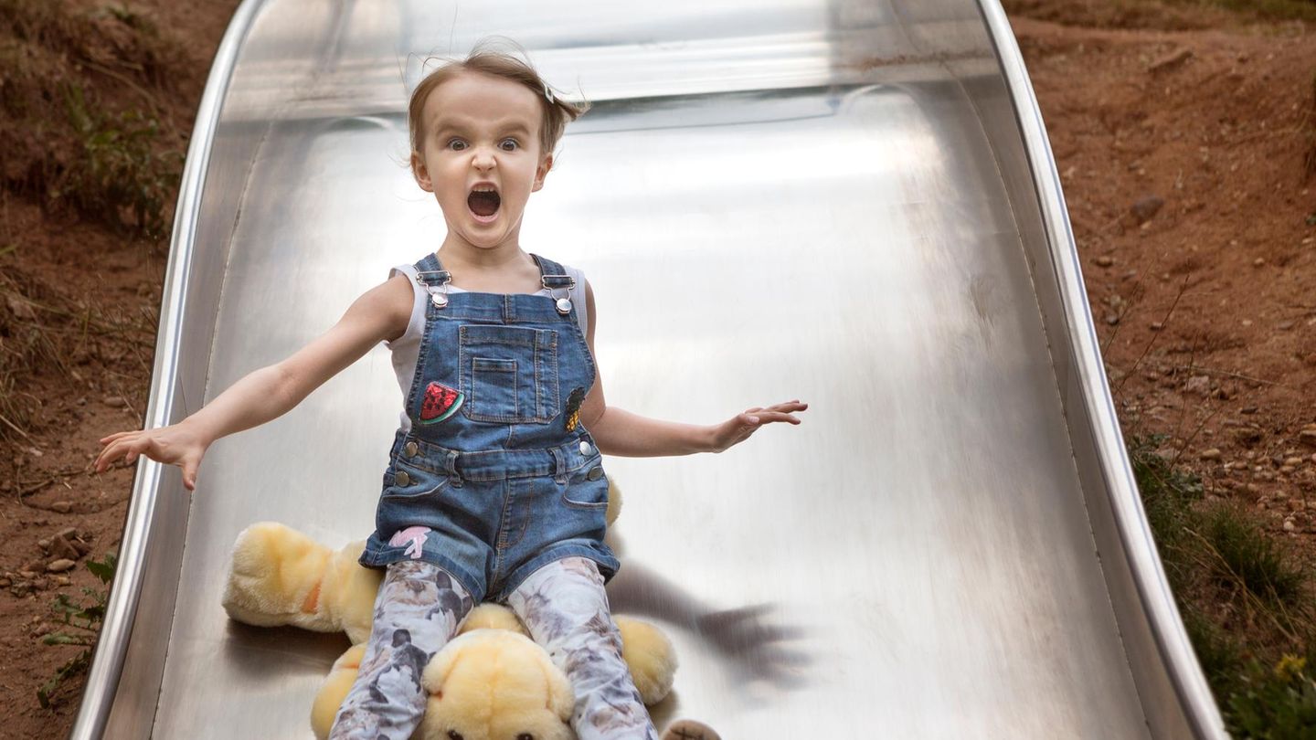 Ein Mädchen rutscht von einer großen Rutsche