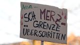 Demo-Schild in Köln: Sch MERZ grenze überschritten"