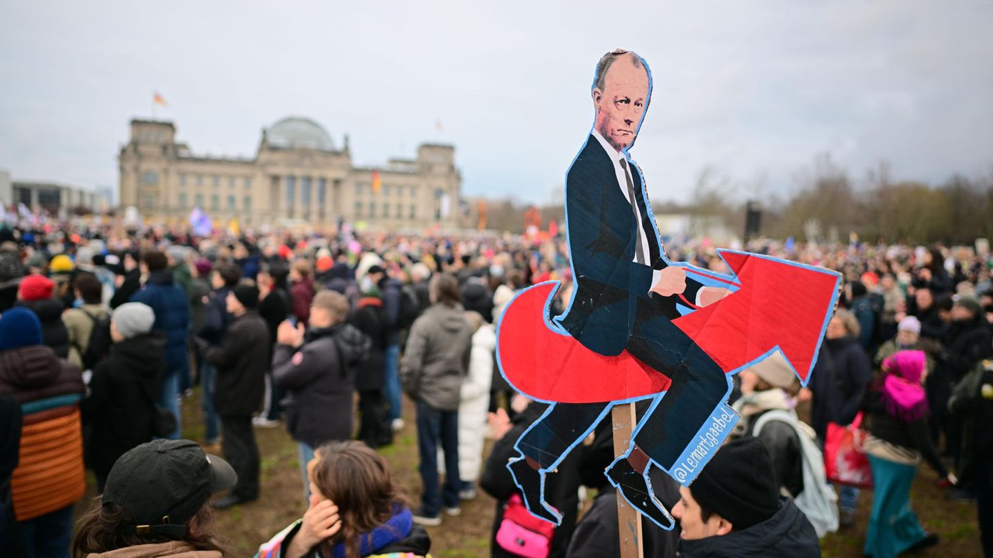 Demo in Berlin: Friedrich Merz sitzend auf dem AfD-Logo
