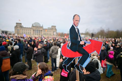 Demo in Berlin: Friedrich Merz sitzend auf dem AfD-Logo