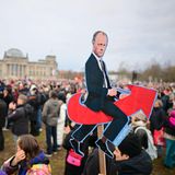 Demo in Berlin: Friedrich Merz sitzend auf dem AfD-Logo