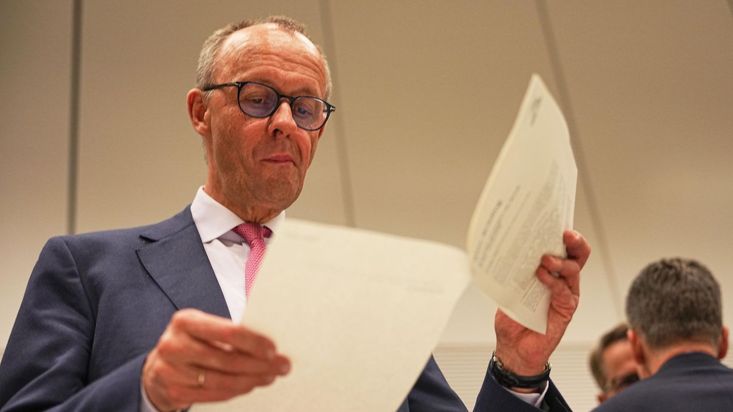 Symbolfoto für "Sofortprogramm": CDU-Spitzenkandidat Friedrich Merz blättert in einem Dokument