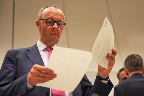 Symbolfoto für "Sofortprogramm": CDU-Spitzenkandidat Friedrich Merz blättert in einem Dokument