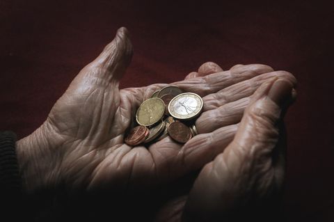 Eine Rentnerin hält ein paar Münzen in ihren Händen