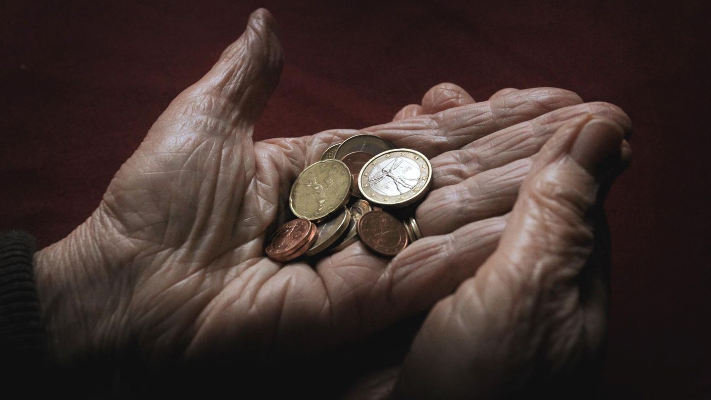 Eine Rentnerin hält ein paar Münzen in ihren Händen